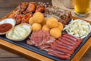 Bira tabağı, et, tavuk, kalamar, kızarmış ekmek, sos. Yakın çekim.