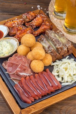 Bira tabağı, et, tavuk, kalamar, kızarmış ekmek, sos. Yakın çekim.