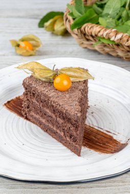 Prag pastasını beyaz, yuvarlak bir tabakta dilimle. Yakın çekim.