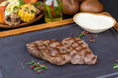 Siyah tahtada soslu ızgara domuz boynu. Yakın çekim.