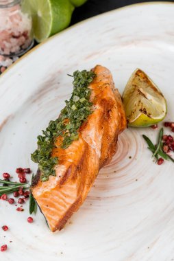 Beyaz tabakta bir dilim ızgara somon. Yakın çekim.