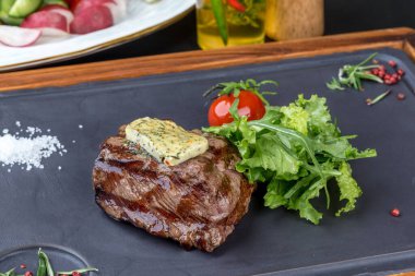 Siyah tahtada taze otlu biftek mignon. Yakın çekim.