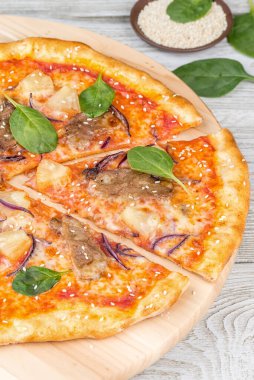 Tahta bir tahta üzerinde ananaslı pizza, bir dilim kes. Yakın çekim.