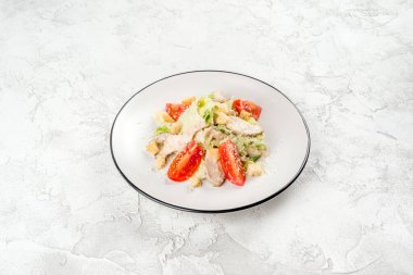 Sezar salatası beyaz, yuvarlak tabakta, yakından çekilmiş.