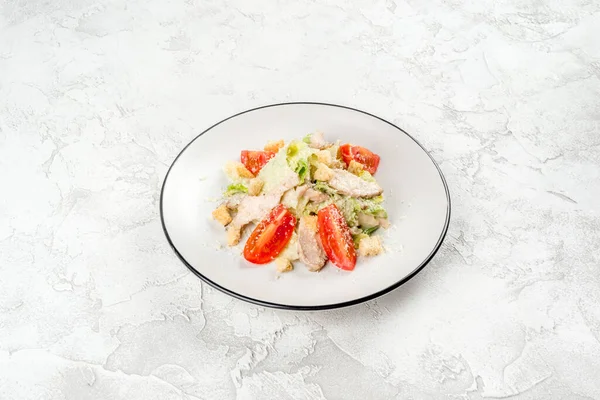 Sezar salatası beyaz, yuvarlak tabakta, yakından çekilmiş.