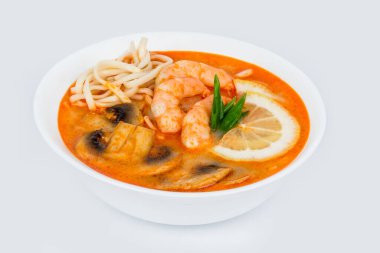Beyaz arka planda beyaz bir tabakta Tom Yam çorbası. Tenderloin altında vuruldu.