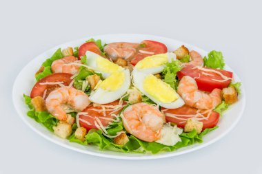 Arka planda beyaz bir tabakta taze otlarla Sezar salatası.