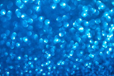 Pulların arka planı. Sequins arka planda. Mavi ışıl ışıl arka plan. Parlayan ışıkları olan soyut, şen şakrak bir arka plan. Kumaş parlak renklerle parıldıyor. Modaya uygun kumaşlar ışıldar