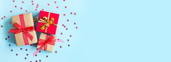 Zestaw czerwono-beżowych pudełek na niebieskim tle. Świąteczna kartka. Boże Narodzenie, Nowy Rok, urodziny — Zdjęcie stockowe