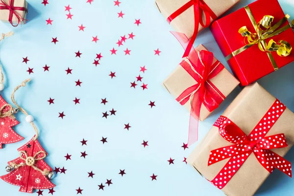 Conjunto de cajas de regalo rojas y beige, con confeti en forma de estrellas, juguete árbol de Navidad en forma de árbol de Navidad sobre un fondo azul, marco. Tarjeta de felicitación de vacaciones. Navidad, Año Nuevo — Foto de Stock