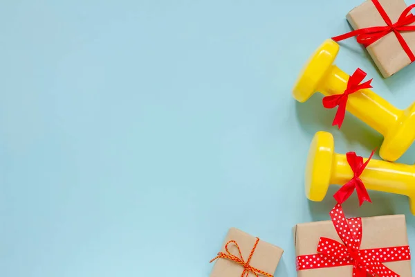 Ejercicio, fitness y desarrollo del concepto de una feliz Navidad y un feliz Año Nuevo. Sombrillas y regalos con cintas rojas sobre fondo azul. — Foto de Stock