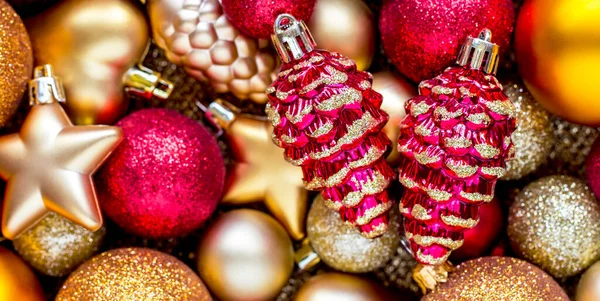 Pozadí červené a zlaté vánoční hračky, kornouty, hvězdy, koule. Veselé Vánoce a Nový rok, blahopřání — Stock fotografie