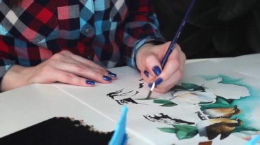 Genç kız sanatçı kağıt üzerinde suluboya ile güzel kuşlar boyar