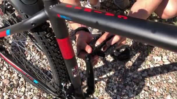 En man skruvar fast pedalerna på cykeln — Stockvideo