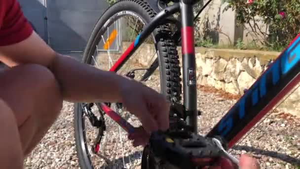 A man screws the pedals to the bike — Stock Video