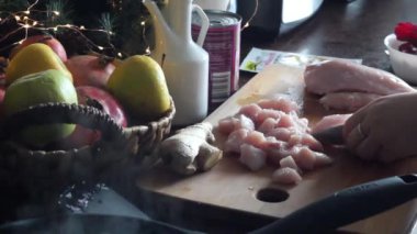 Bir kadın Noel 'de tahta bir tahtada tavuk filetosu kesiyor.