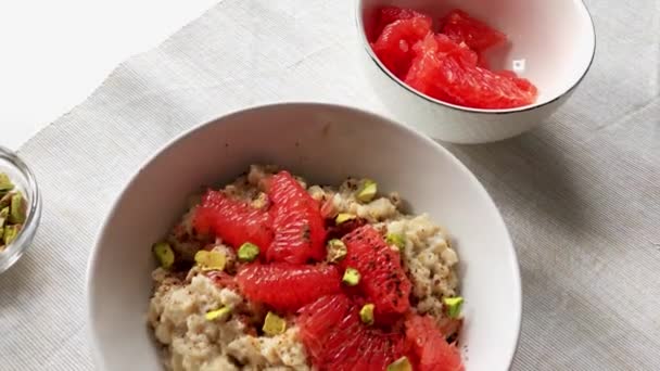 Gachas de avena con leche de almendras con pomelo y pistachos — Vídeo de stock