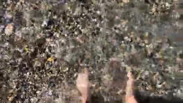 Füße an einem felsigen Strand am Meer — Stockvideo