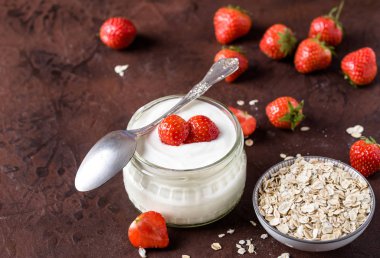 Cam kase kaşık ve starwberries rustik arka plan üzerinde beyaz yoğurt.