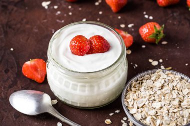 Cam kase kaşık ve starwberries rustik arka plan üzerinde beyaz yoğurt.