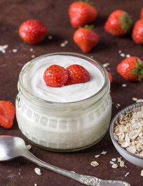 Cam kase kaşık ve starwberries rustik arka plan üzerinde beyaz yoğurt.