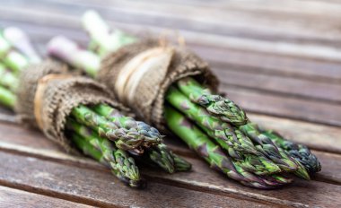 Jüt ahşap arka plan üzerinde sarılı kuşkonmaz.