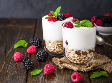 Müsli ve ahududu cam kase rustik ahşap arka plan üzerinde beyaz yoğurt.