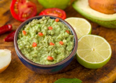 Madde ile doğal rustik masa mavi kase guacamole: limon, domates, biber çevresinde.
