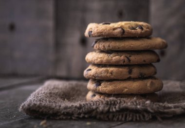 Doğal eski masa üzerine yığılmış yuvarlak çikolata kurabiye.