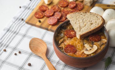 Slovak Noel Ulusal lahana çorbası sosisli masa örtüsü arka plan üzerinde seramik kase.