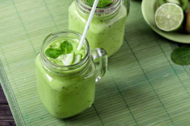 Avokado, limon ve kivi yaptığı yeşil zemin üzerine yeşil smoothie.