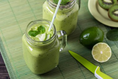 Avokado, limon ve kivi yaptığı yeşil zemin üzerine yeşil smoothie.