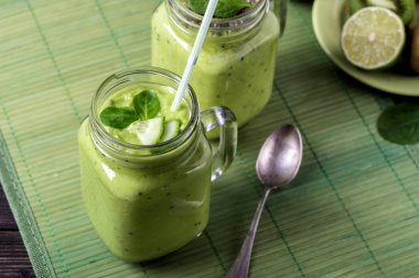 Avokado, limon ve kivi yaptığı yeşil zemin üzerine yeşil smoothie.