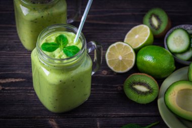Avokado, limon ve kivi yaptığı yeşil zemin üzerine yeşil smoothie.