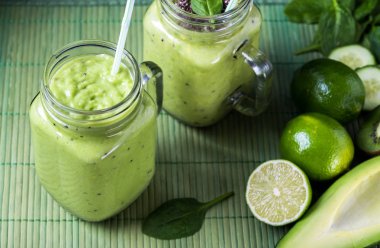 Avokado, limon ve kivi yaptığı yeşil zemin üzerine yeşil smoothie.