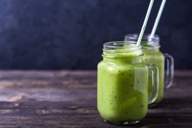 Avokado, limon ve kivi üzerinde doğal ahşap yapılmış yeşil smoothie arka plan.