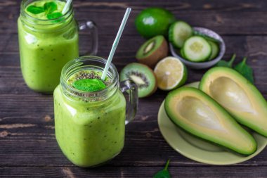 Avokado, limon ve kivi yaptığı yeşil zemin üzerine yeşil smoothie.