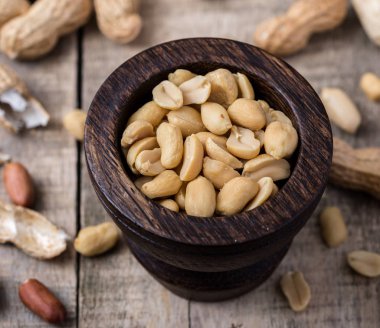 Doğal rustik masa üzerinde küçük koyu ahşap kase fıstık.