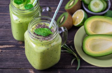 Avokado, limon ve kivi yaptığı yeşil zemin üzerine yeşil smoothie.