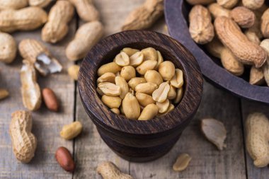 Doğal rustik masa üzerinde küçük koyu ahşap kase fıstık.