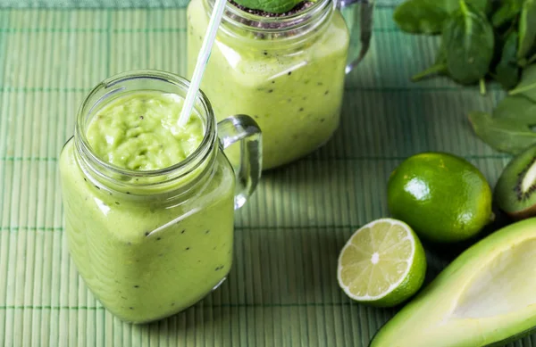 Avokado, limon ve kivi yaptığı yeşil zemin üzerine yeşil smoothie.