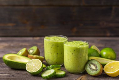 Yeşil smoothie avokado, limon ve doğal ahşap zemin üzerine kivi tarafından yapılan.