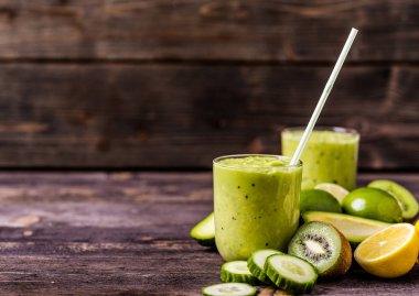 Yeşil smoothie avokado, limon ve doğal ahşap zemin üzerine kivi tarafından yapılan.