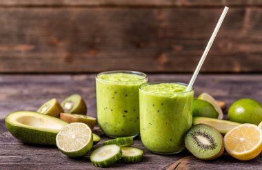 Yeşil smoothie avokado, limon ve doğal ahşap zemin üzerine kivi tarafından yapılan.