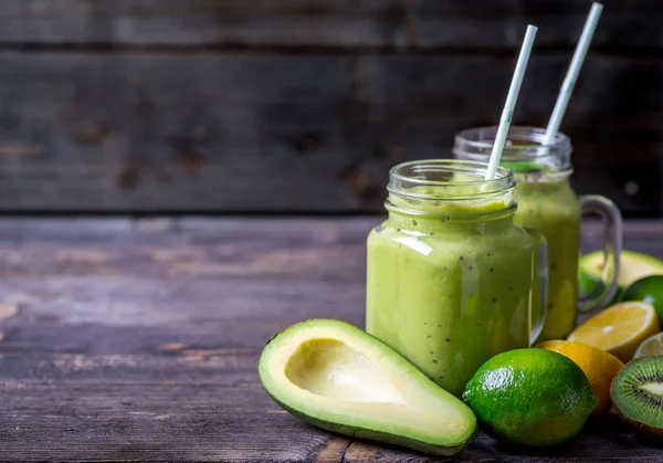 Zelené smoothie, avokádo, citron a kiwi na přírodní dřevěné pozadí. — Stock fotografie