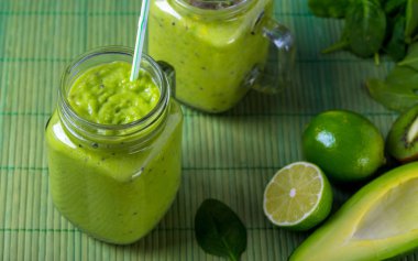 Cam avokado, limon ve kivi yaptığı yeşil zemin üzerine yeşil smoothie.