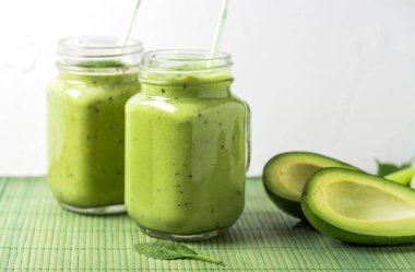 Cam avokado, limon ve kivi yaptığı yeşil zemin üzerine yeşil smoothie.