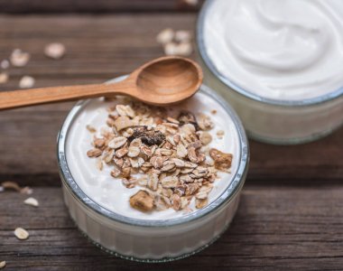 Cam kasede beyaz yoğurt Eski ahşap masa üzerinde Tahta kaşık üst tarafında.