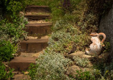 Rustik ahşap basamakların yanında eski kırık seramik şamdan