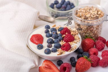 Beyaz arka planda çilek ve yabanmersinli yoğurt..